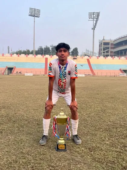 A moment of reflection and pride. This player and his trophy represent countless hours of training and a relentless drive to succeed.