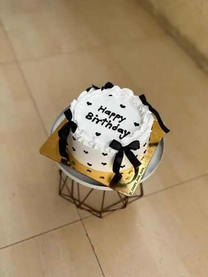 A simple and cute vintage-style bento cake with black bows and hearts.
