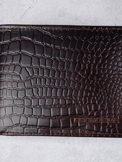 A front-facing, closed shot of the dark brown crocodile wallet.