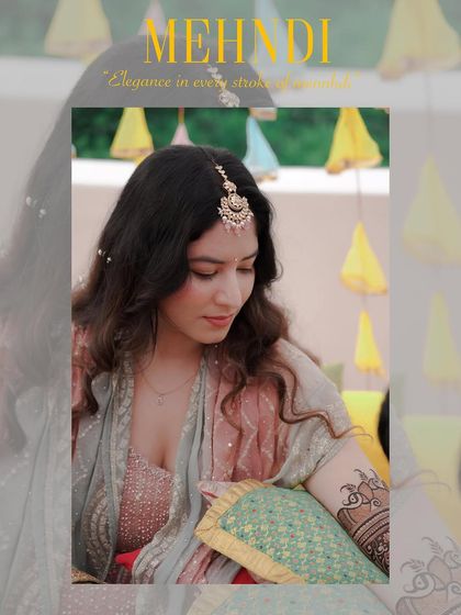 A quiet, elegant portrait of the bride during her Mehndi ceremony. The focus is on her serene expression as she looks down at her henna, capturing a moment of peaceful reflection.