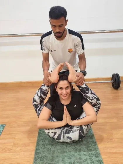 Our instructors are here to help you achieve your flexibility goals. Here, a trainer provides gentle assistance to help a client deepen her stretch in a partner-style pose.