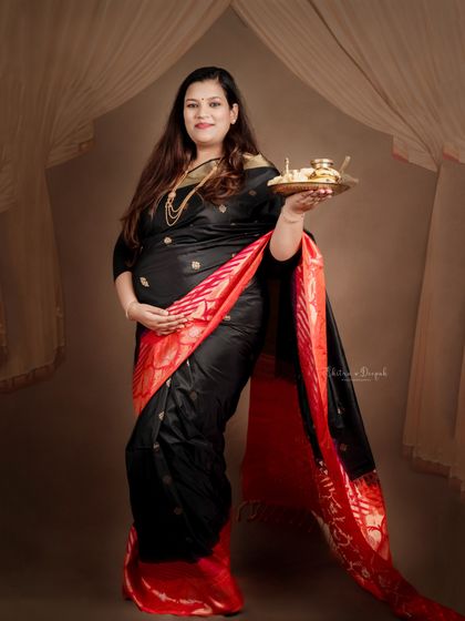 A portrait that evokes a sense of ceremony and tradition, with the mom-to-be holding a decorative plate (thali).