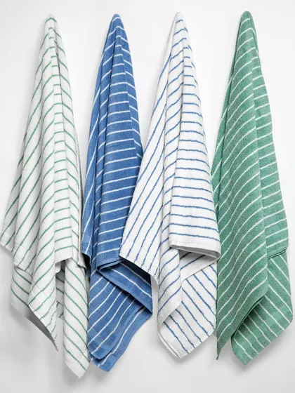 A simple but effective shot showing four towels hanging in a row. This allows customers to see the different colorways side-by-side and appreciate the texture and drape of the fabric.