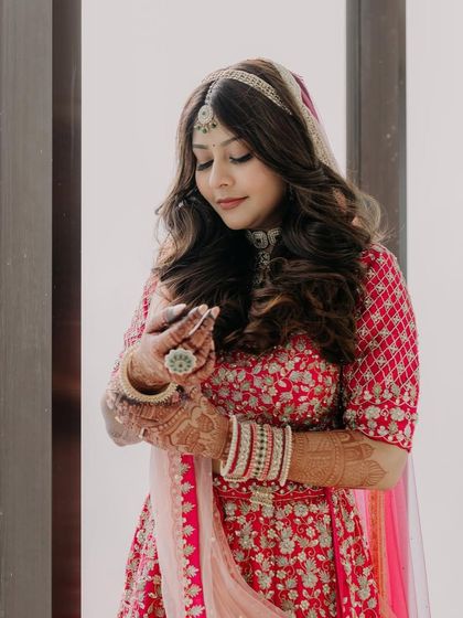 A quiet moment of reflection for the bride. Her soft, romantic makeup and hairstyle look stunning with her pink lehenga.