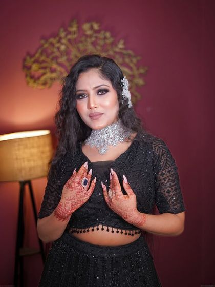 A beautiful portrait showing the full hair and makeup look with the black outfit.