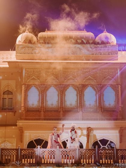 The couple waving to their guests from the palace balcony, a moment of shared joy and celebration.