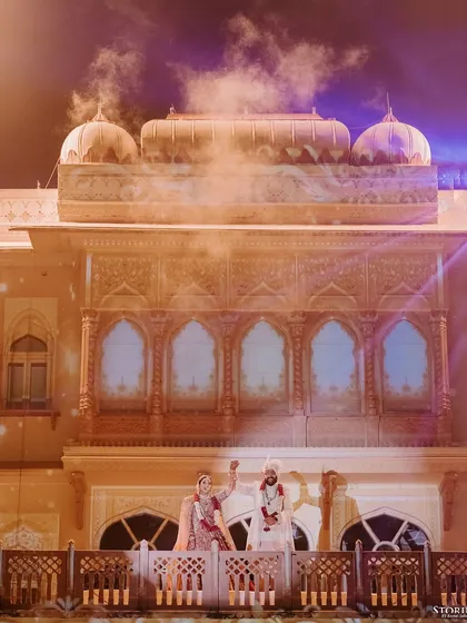 The couple waving to their guests from the palace balcony, a moment of shared joy and celebration.