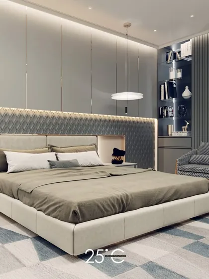 A serene and sophisticated bedroom design featuring a cool grey color palette. The custom headboard incorporates a quilted texture and integrated backlighting, while a built-in shelf and reading nook add functionality.