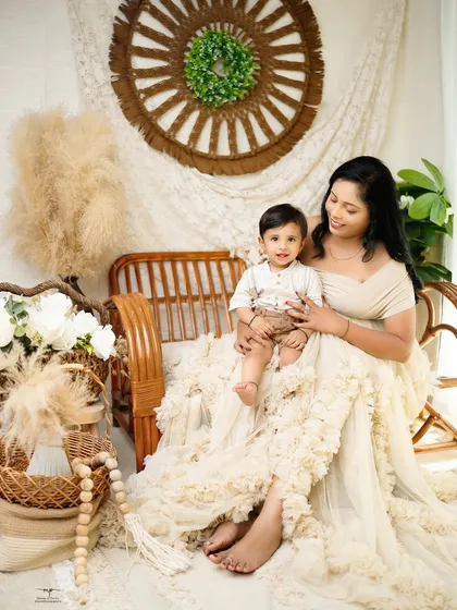 A mother sits with her son in a beautiful boho-inspired setting. The soft textures and earthy tones create a warm and serene atmosphere for this lovely portrait.