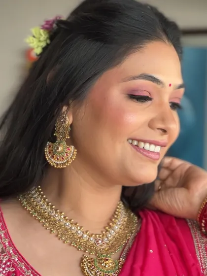 A lovely side profile that captures the bride's radiant smile and glowing skin. The flushed cheeks and pink liner create a look of youthful elegance.