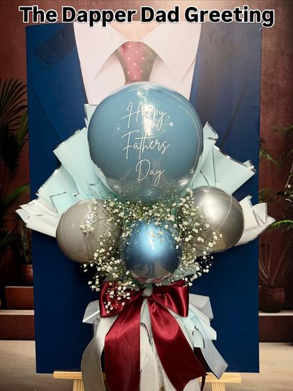 A close-up of "The Dapper Dad Greeting." The "Happy Father's Day" balloon is the centerpiece, surrounded by chrome balloons and baby's breath for a sharp, elegant look.