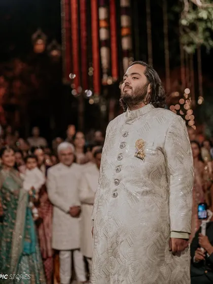 Anant watching as his bride, Radhika, makes her entrance. This photo captures the groom's perspective, a moment filled with anticipation, pride, and overwhelming love.