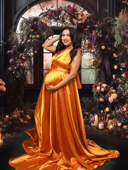 Surrounded by a garden of dreams, this portrait is all about opulence and queenly grace. The rich color of the gown against the elaborate floral backdrop creates a truly breathtaking and regal image.