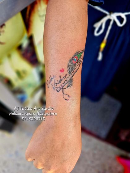 A "Radha Krishna" tattoo design with a peacock feather and flute.
