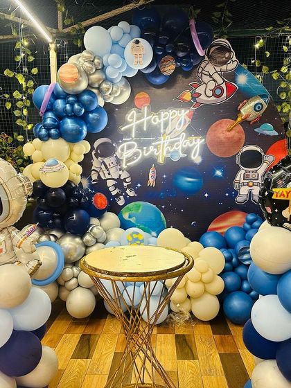 The full space-themed setup, complete with astronaut balloon sculptures and a custom cake stand.