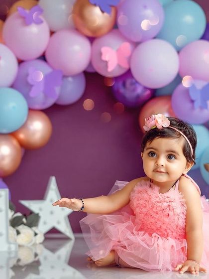 A curious glance from the birthday girl. The details, like the paper butterflies on the balloons, complete this magical theme.