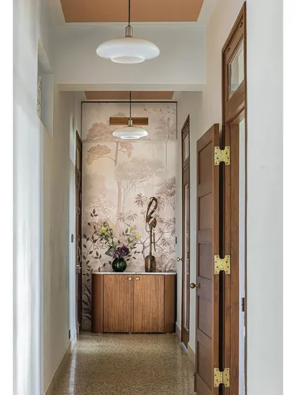 A duplicate image of the corridor in Apartment 5026, emphasizing the successful blend of Art Deco and mid-century modern influences through the use of terrazzo flooring, wood paneling, and statement wallpaper.