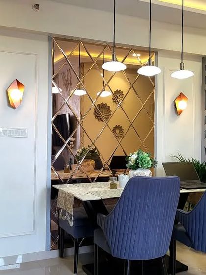 A gorgeous blend of colors and textures in this dining area. The deep blue door, gold accents, and beveled mirror create a truly unique and inviting space.