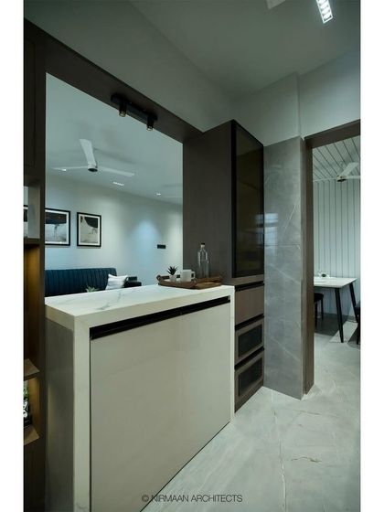 This kitchen at Tulsi Heights is modern, modular, and compact. We replaced a wall with a breakfast counter to open up the space and connect it to the living room, making it feel much larger.