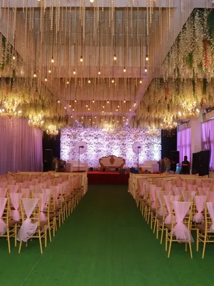 Synergy Banquet in Vashi, available for just 60k with decor. The ceiling is adorned with hanging flowers and lights, creating an enchanting atmosphere.