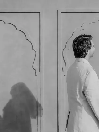 A creative play of light and shadow during a pre-wedding shoot in Jaipur. The couple stands opposite their own shadows, creating a thoughtful and artistic black and white portrait about their union.