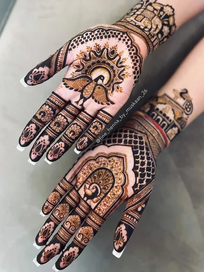 A unique design with lovebirds under the sun on one hand and a peacock in a jharokha on the other.