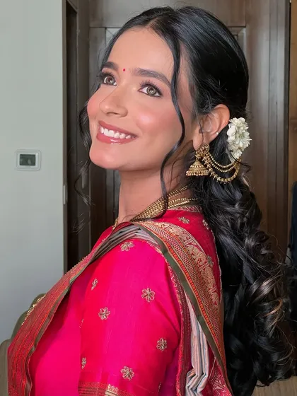 A side profile showcasing the elegant hairstyle with fresh flowers and the beautiful glow on her skin.