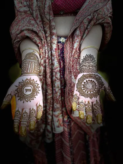 A personalized design featuring the name 'Ram' in Hindi within a beautiful mandala. The other hand has a matching intricate mandala, creating a symmetrical and meaningful look.