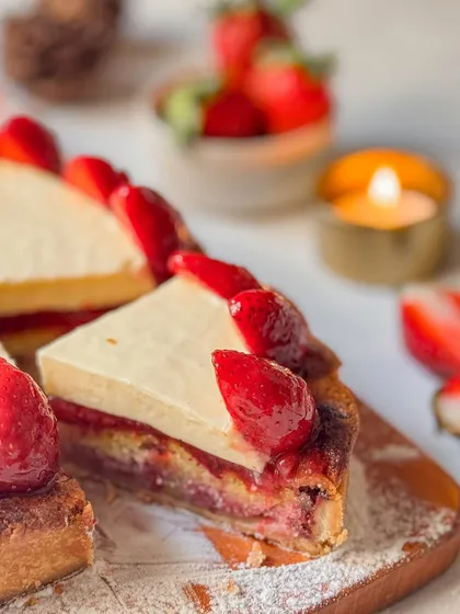 A slice of our Strawberry Tart, showing the layers of buttery crust, almond frangipane, and strawberry jam, all topped with fresh berries. It's a complex and satisfying dessert.