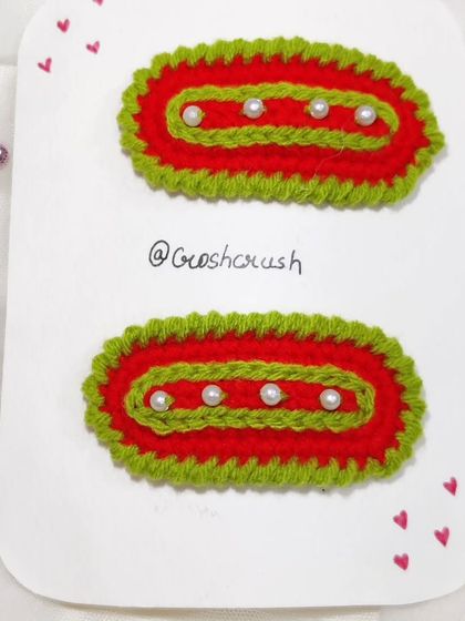 Festive Christmas-themed hairclips in red and green with pearl accents.