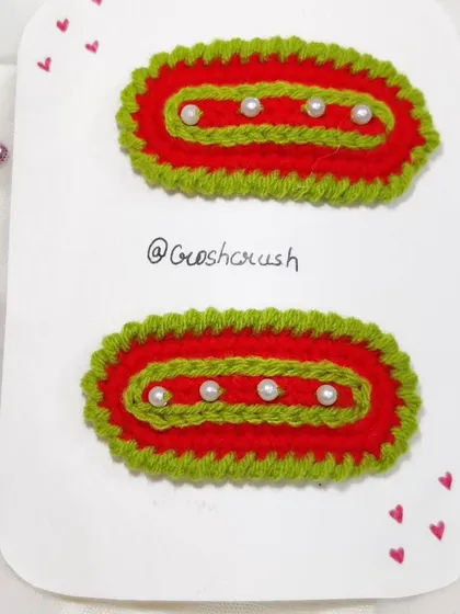 Festive Christmas-themed hairclips in red and green with pearl accents.