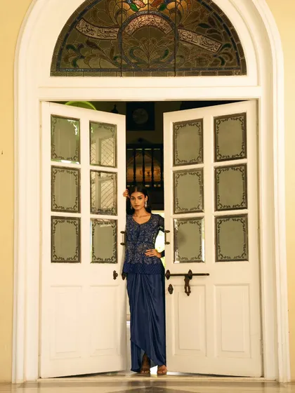 The model is framed by ornate double doors, creating a sense of anticipation and grandeur. This shot was designed to make a strong visual statement for a brand's campaign.