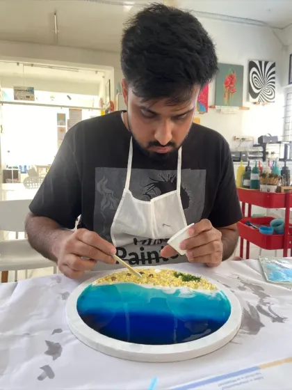 A participant adds the final touches to his resin beach art. The focus and concentration involved in the process are incredibly rewarding.