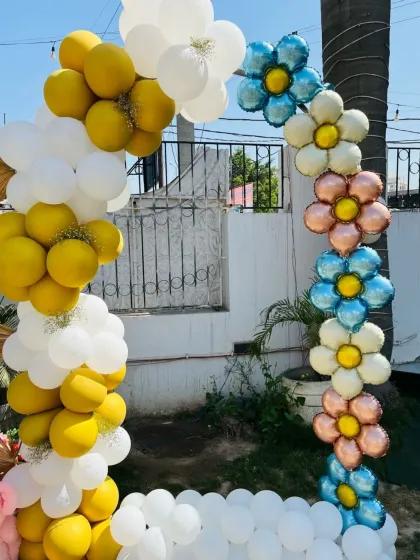 A close-up of a balloon arch with daisy-shaped foil balloons, part of the teddy bear party decor.