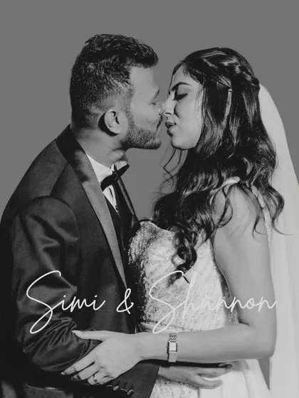 A timeless black and white kiss. This studio-style portrait is perfect for capturing the classic romance of a wedding day, focusing on the couple's intimacy.