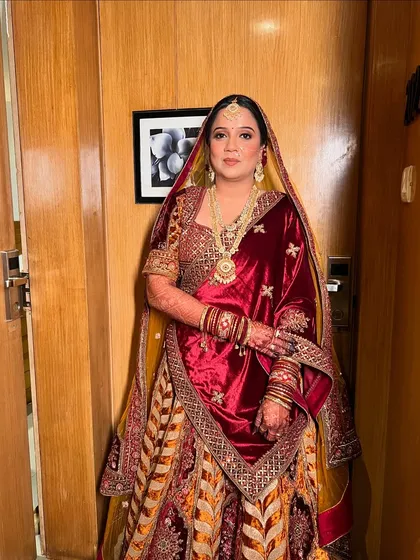 A full-length view of the bride in her magnificent multi-toned velvet lehenga, a perfect choice for a winter wedding.