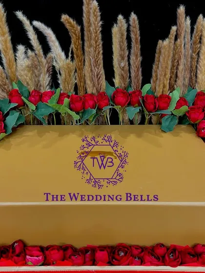 A closer look at our exquisite floral gift box. The arrangement of red roses and pampas grass around a golden gift box is pure luxury.