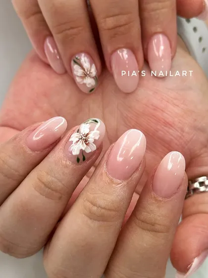 Simple nude nails with a hand-drawn floral accent. This shows that even a small touch of art can elevate your entire look.