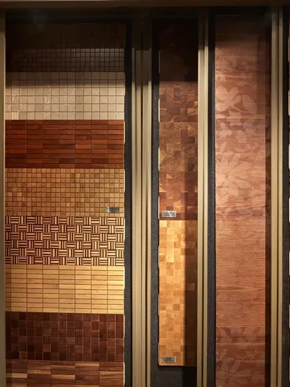 A close-up of the vertical sliding panels used to display different wood flooring patterns at the FCML showroom. This innovative solution solves the challenge of showcasing a vast inventory in a limited footprint.