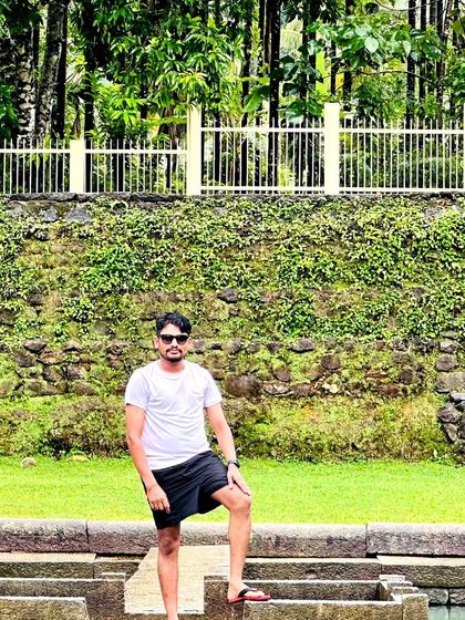 A trekker posing at the steps of the ancient temple pond.