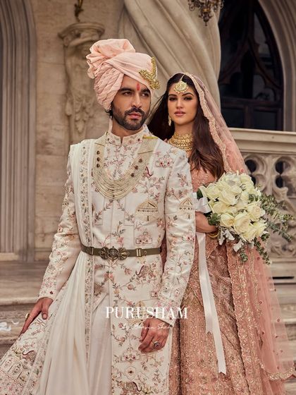 A portrait of a couple, where his floral sherwani and her pastel lehenga create a story written in fabric and gold. This is for the man who understands that true elegance is inherited.