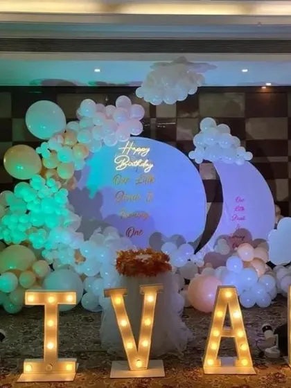 A grand birthday celebration in a banquet hall with large, illuminated marquee letters spelling out the name 'JIVAH'.