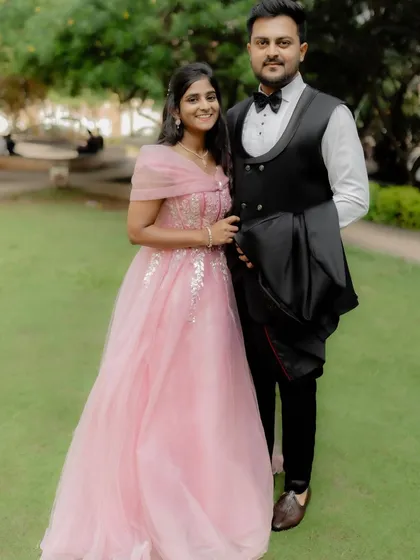 A picture of elegance for their engagement. The bride-to-be looks stunning in a soft pink gown, perfectly complemented by her partner's sharp tuxedo.