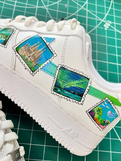 A close-up of the travel stamp sneakers, showing the detail on the Sagrada Familia and Northern Lights stamps.