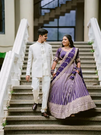 Descending the stairs hand in hand, Apeksha and Rutwij look like royalty. This shot uses the architectural lines of the staircase to frame their elegant descent.