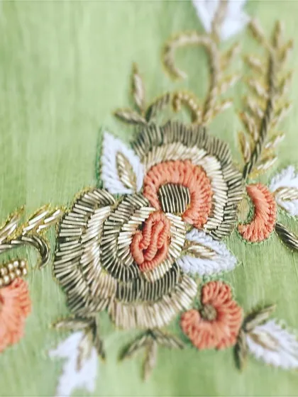 A close-up view of the intricate hand embroidery that defines my craft. This piece showcases a floral motif created with dabka, zari, and beadwork, demonstrating the level of detail and artistry I bring to every custom design.