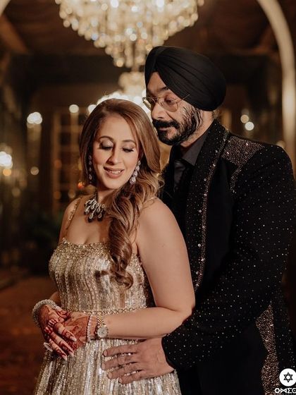 An intimate moment captured. The groom wears a bespoke black tuxedo with all-over sparkle, a glamorous and sophisticated choice for his reception.