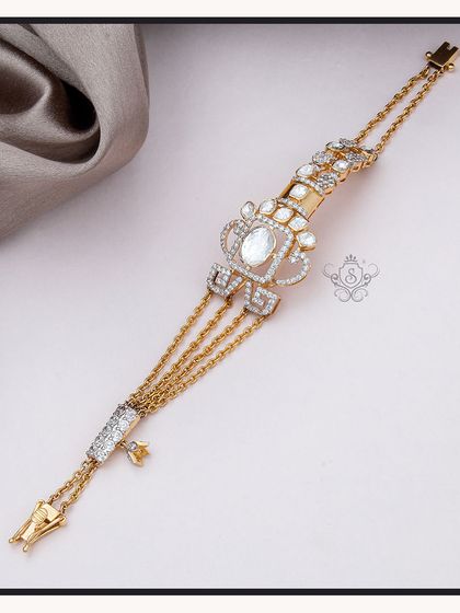 A delicate and regal bracelet featuring multiple gold chains and a central motif with polki diamonds. This piece has the feel of a 'hathphool' or hand harness, blending tradition with modern elegance.