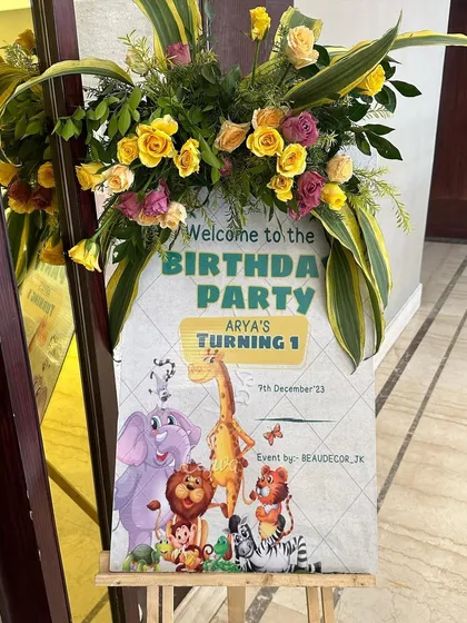 The welcome sign for the "Wild One" first birthday party. We designed it with cute cartoon jungle animals and a beautiful floral arrangement on top to greet the guests.