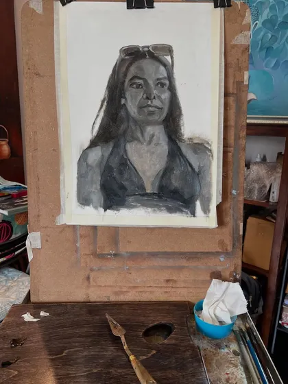 Another view of the monochrome portrait on my easel, with my palette knife and paints nearby. This setup is typical for my studio practice.
